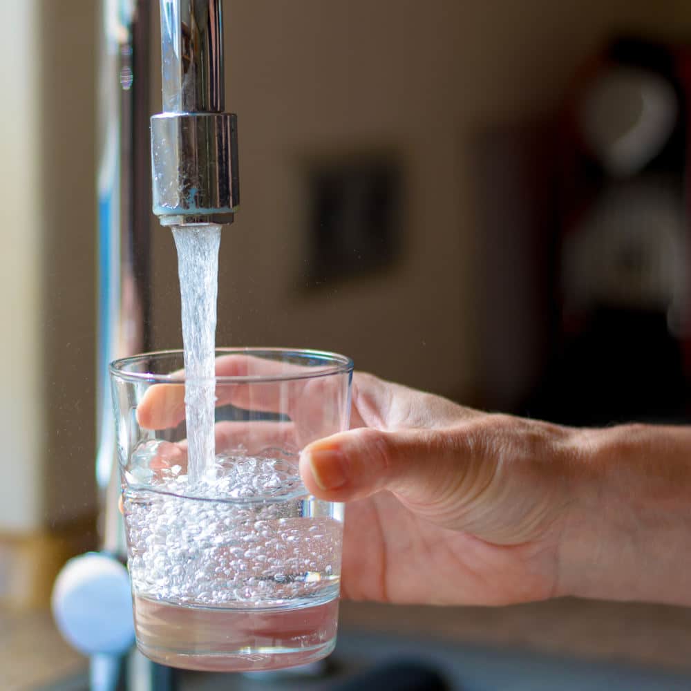 Woman filling a glass of water from a tap