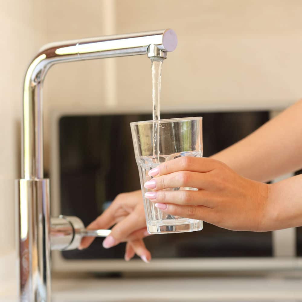 Woman getting clean water from her faucet